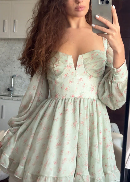 Person wearing a light green floral dress in a kitchen setting